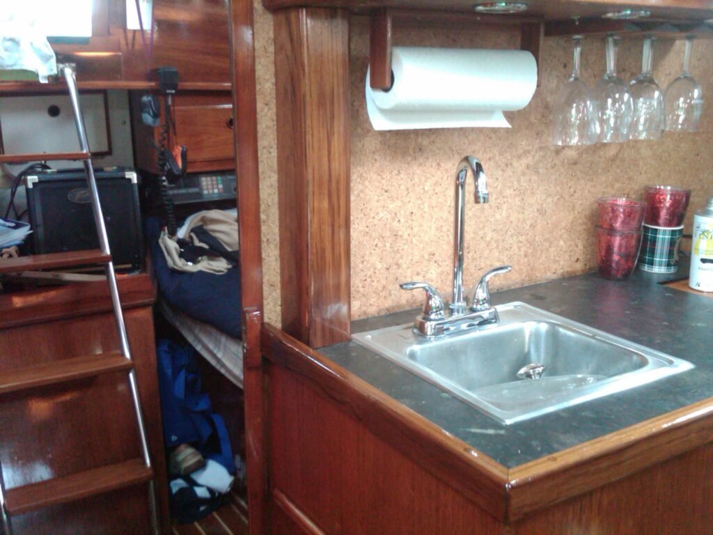 Pearson 424 after pictures of new counter top, new sink installed and teak wood box covering PVC wire chase pipe